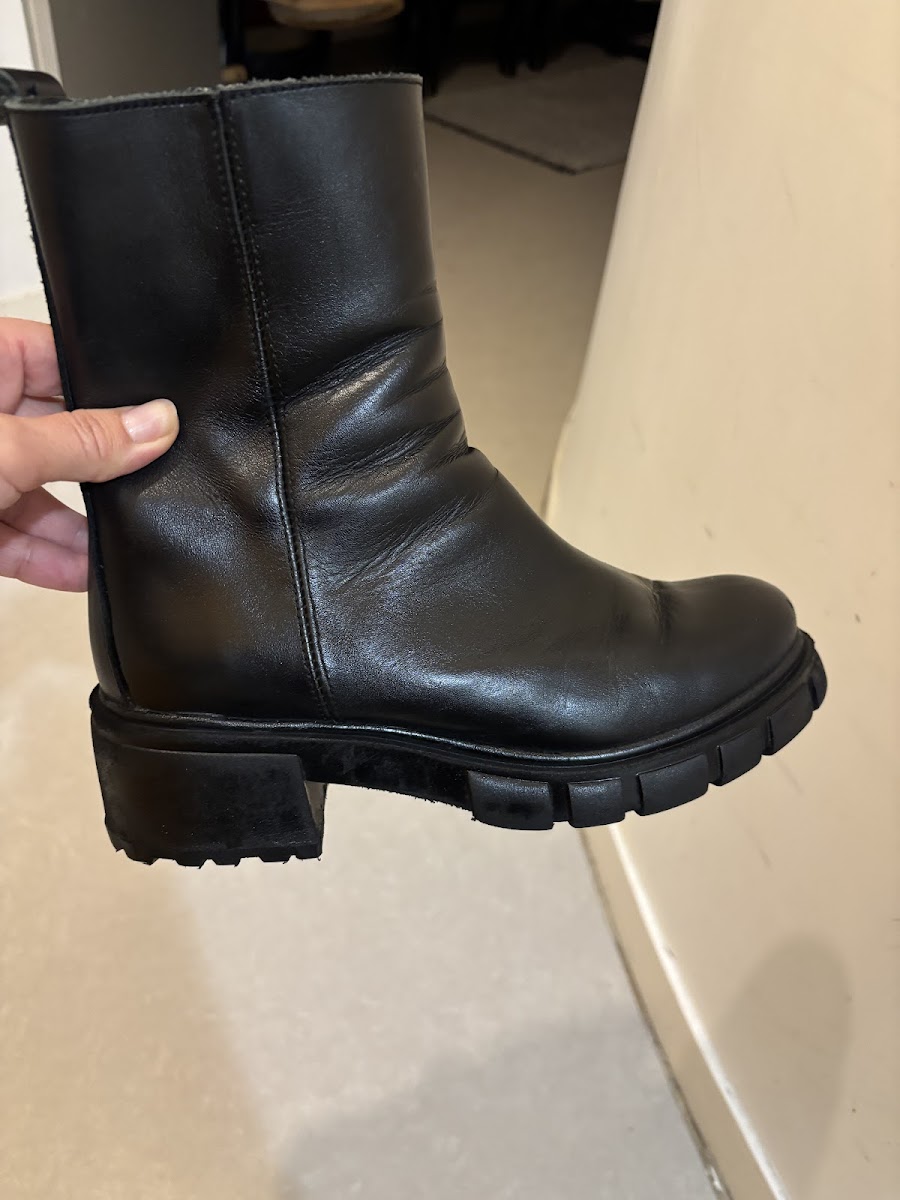 Boots en cuir noir confiées à l'atelier